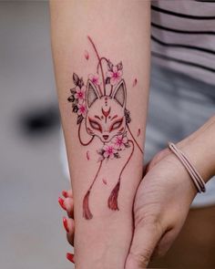 a woman's arm with a fox tattoo on it