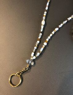 This white and gold accented lanyard is beautiful as well as functional.  It is 18" long from the top to the gold ring.  This is a one-of-a-kind item which includes crystals, pearls and gold beads. White Spiritual Beaded Chain Jewelry, White Pearl Jewelry With Gold Beads, White Pearl Beaded Necklace, White Pearl Spiritual Beaded Necklace, Spiritual White Jewelry With Gold Beads, Saint Paul Mn, Beaded Lanyards, Saint Paul, May 31