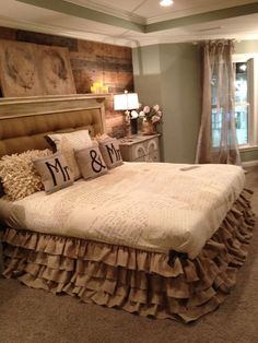 a bed with ruffled bedskirt king and queen pillows on top of it