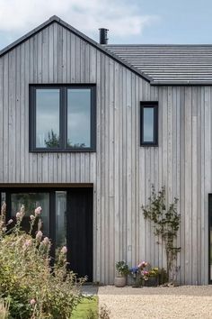 a house that is made out of wood and has two windows on the side of it