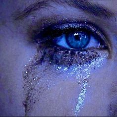 a woman's blue eyes are covered in glitter