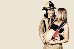 a man and woman dressed in firefighter gear are hugging each other while smiling at each other