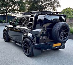 the rear end of a black suv parked in a parking lot