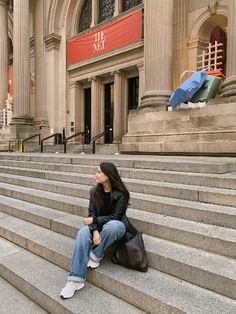 a woman sitting on some steps in front of a building