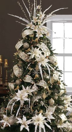 a decorated christmas tree with white and gold decorations