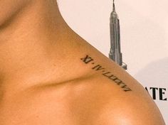 the back of a man's shoulder with a city skyline in the background and words written on it