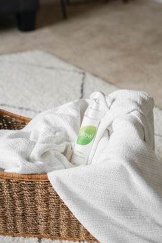 a bottle of deodorant sitting on top of a towel in a basket