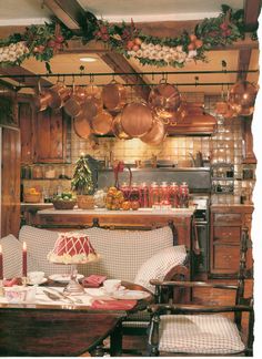 the kitchen is decorated for christmas with copper pots and pans hanging from the ceiling