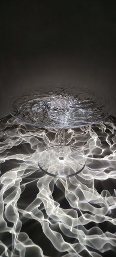 a water droplet is shown in the middle of an image with light swirling around it