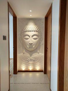 a white buddha statue sitting in the middle of a hallway next to a wall with lights on it