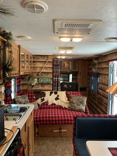 a living area with couches, cabinets and a stove top oven in the kitchen