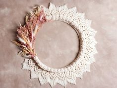 two pieces of crochet are arranged in the shape of a circle with feathers on it