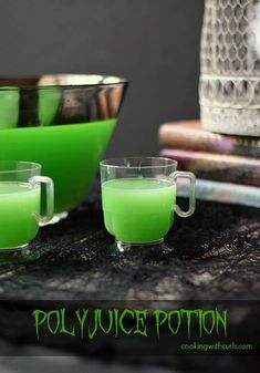 three glasses filled with green liquid sitting on top of a table next to a bowl