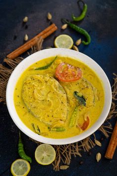 a white bowl filled with yellow curry and garnish