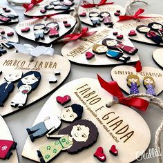 wooden heart shaped ornaments with names and pictures hanging on a table in the shape of hearts