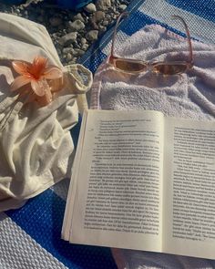 an open book and sunglasses on a towel