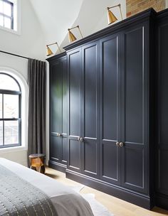 a bedroom with dark blue cabinets and white walls