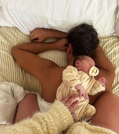 a man holding a baby while laying in bed