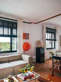 a living room filled with furniture and large windows