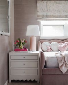 a bedroom with a bed, dresser and lamp