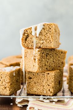 several pieces of cake are stacked on top of each other and drizzled with icing