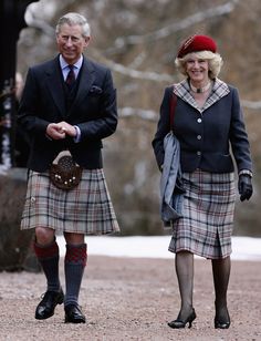 two people in kilts are walking down the street