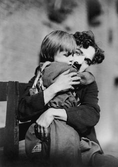 an old black and white photo of two people hugging