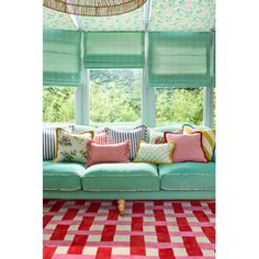 a living room filled with lots of furniture and pillows on top of a checkered rug