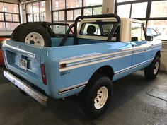 a light blue pick up truck parked in a garage