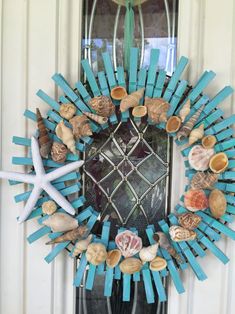 a wreath made out of sticks and seashells is hanging on the front door