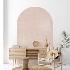 a white room with a wooden table and chair next to a potted palm tree