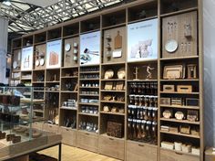 the shelves are filled with many different types of pottery and other things in glass cases