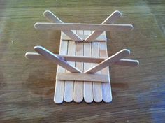 a wooden rack with two crossed handles on top of a table