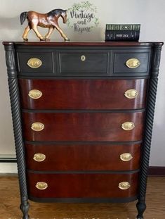 an antique dresser with horse figurine on top and books on the bottom shelf