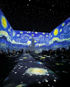 an image of the starry night sky with people sitting on benches in front of it