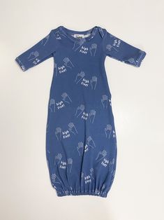 a blue baby romper with white hand prints on the front and back, sitting on a white surface