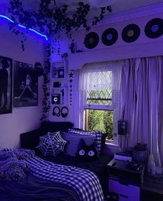 a bedroom decorated in black and white with purple lighting