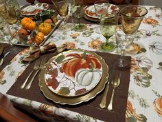 a place setting with pumpkins and gourds on it