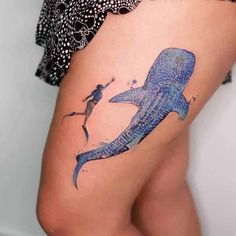 a woman's thigh with a blue whale tattoo on it