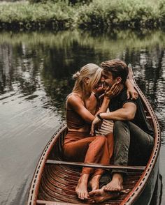 a man and woman are sitting in a small boat on the water with their arms around each other