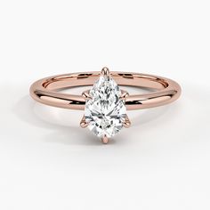 a rose gold engagement ring with an oval cut diamond in the center and side stones