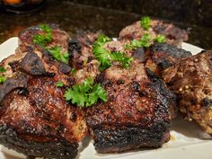 some meat on a white plate with parsley