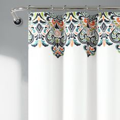 a white shower curtain with an orange, green and blue floral design on it's side