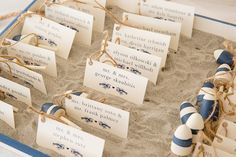 some blue and white striped burlocks in the sand with tags attached to them