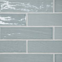 a close up view of a gray tile wall with white grouting on it