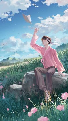 a woman sitting on top of a rock next to a lush green field filled with pink flowers