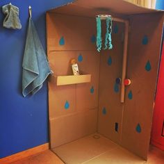 an open cardboard box with blue raindrops on the wall and a towel hanging from it