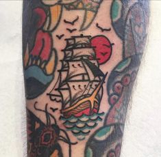 a man's leg with a ship tattoo on it