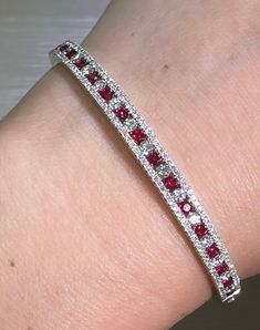 This luxurious 2.56ct tw ruby & diamond white gold bangle bracelet is a stunning piece of artistry. Expertly set in 18K white gold, it features a dazzling diamond and ruby combination that will add lustrous elegance to any ensemble. Adorn yourself with this highly exclusive and sophisticated bracelet for a timelessly chic look.Metal: 18K White GoldRuby Weight: (18) 1.07ct twDiamond Shape , Weight: (173) Round Brilliant Cuts 1.49ct twBangle/Wrist Width: 58mm x 48mmBangle Weight: 5mm White Gold Bangle, Red Diamond, Gold Bangle Bracelet, Gold Bangle, Ruby Diamond, Bracelet Stack, Gold Bangles, Round Brilliant, Bangle Bracelet