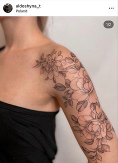 a woman's arm with flowers and leaves tattooed on the side of her shoulder